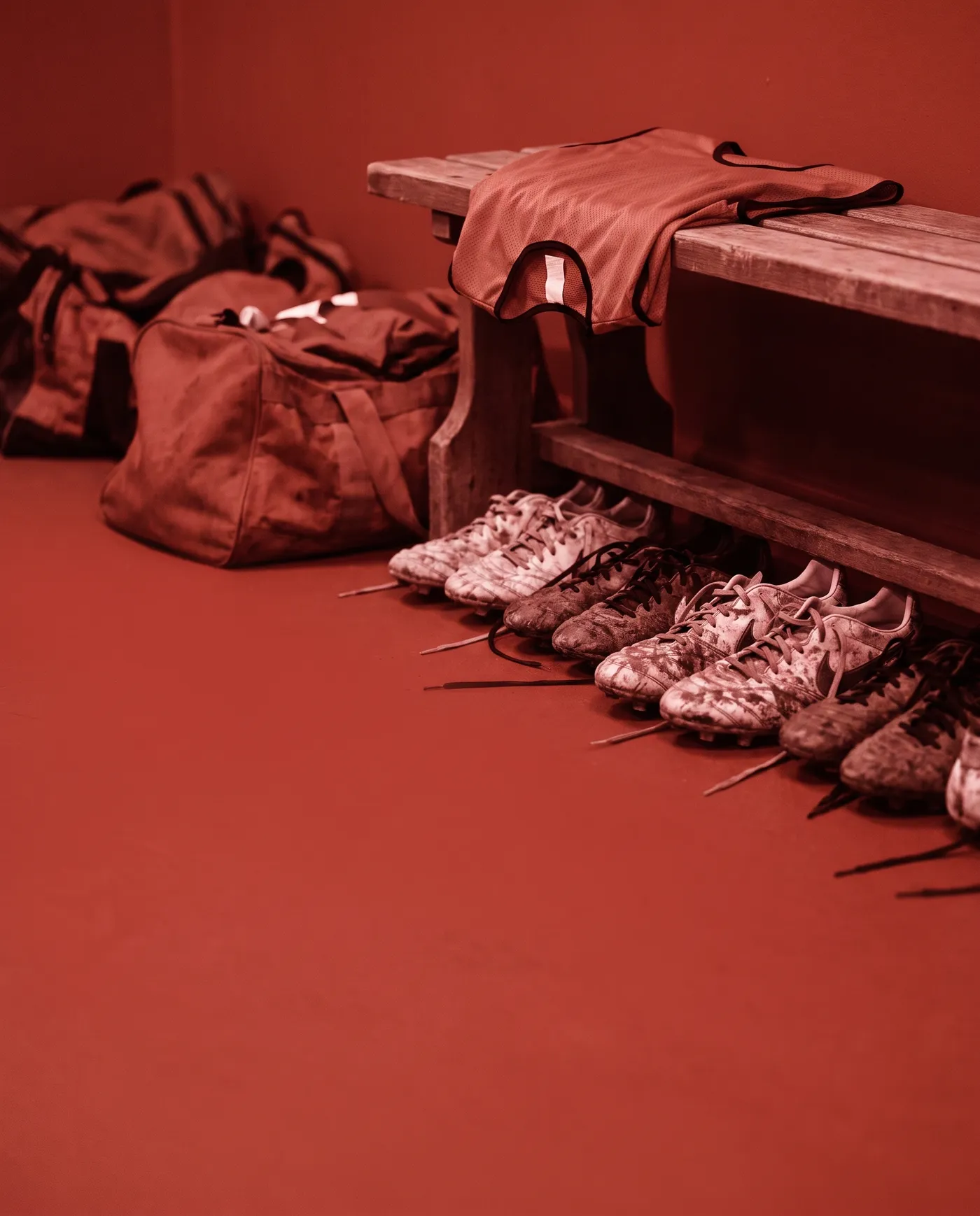 Fußballschuhe unter einer Bank in der Kabine